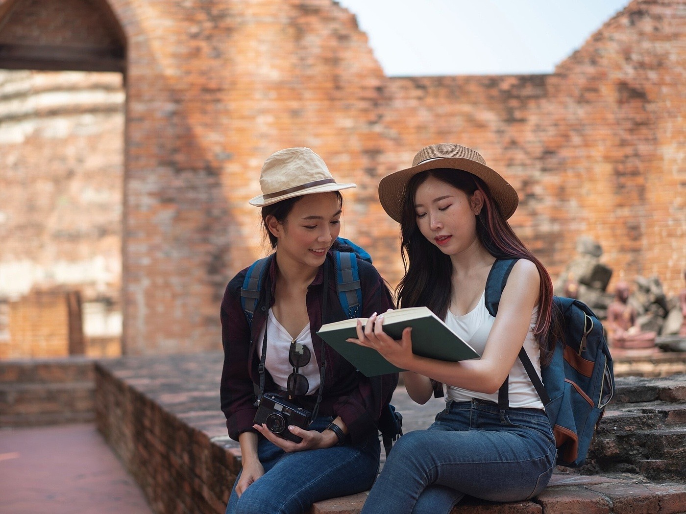 Zwei junge Studentinnen lesen in einer Ruine ein Buch