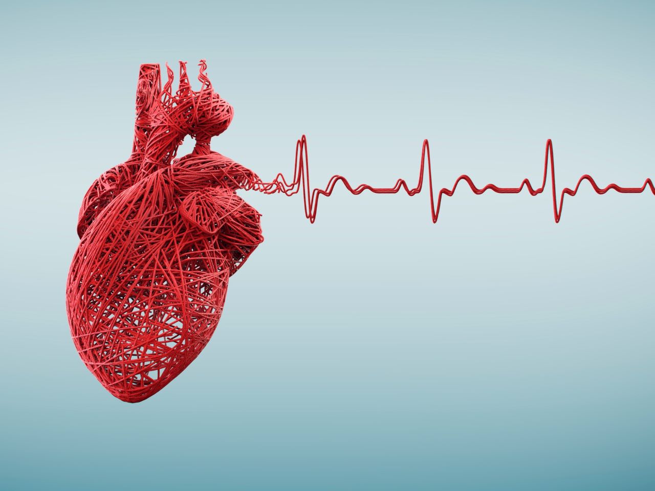 Rotes Herz und EKG-Linien aus Schnur auf einem blauen Hintergrund